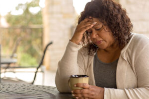 Middle aged Black women feeling exhausted with hand on head