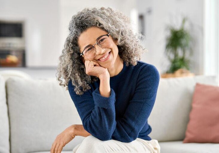 Smiling middle age women with glasses with hand on chip